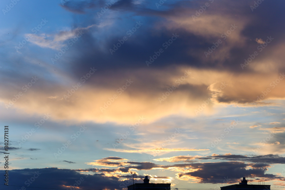 Clouds at sunset over houses