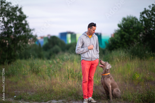 Man standing on land with dog in countryside