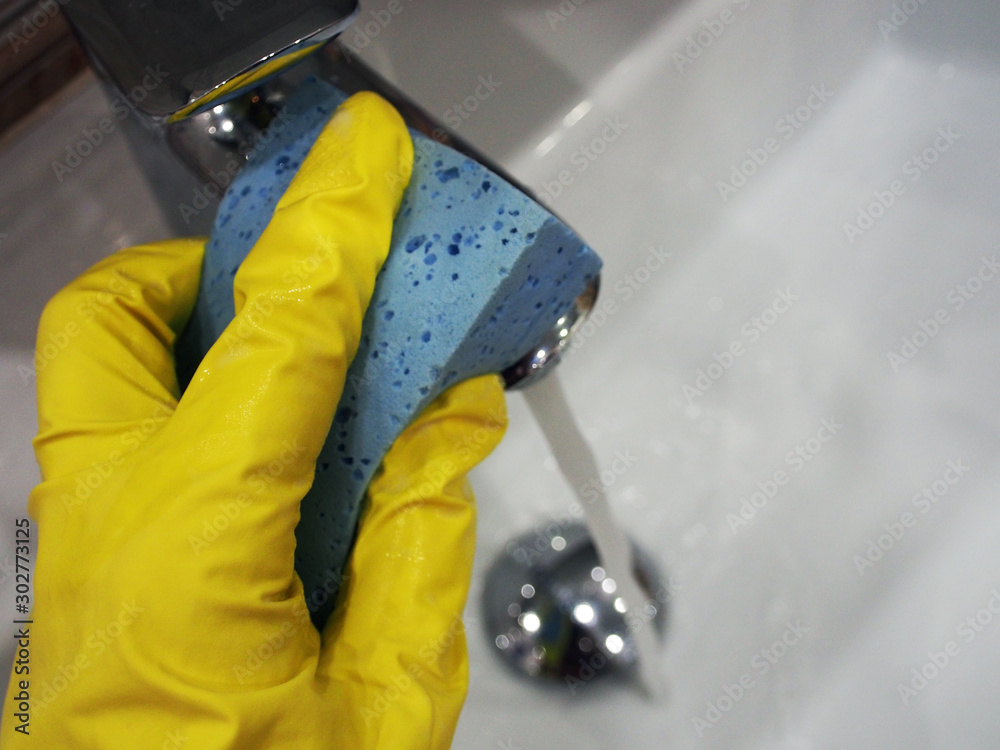 Fototapeta premium Photo hands in a bright rubber glove washing sponge home plumbing, close-up. Housework and maintenance of cleanliness is the main concept of maintenance.