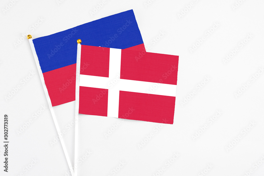 Denmark and Haiti stick flags on white background. High quality fabric, miniature national flag. Peaceful global concept.White floor for copy space.