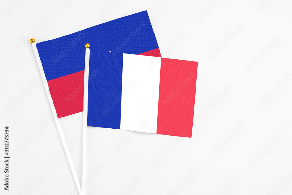 France and Haiti stick flags on white background. High quality fabric, miniature national flag. Peaceful global concept.White floor for copy space. France and Haiti stick flags on white background. High quality fabric, miniature national flag. Peaceful global concept.White floor for copy space.