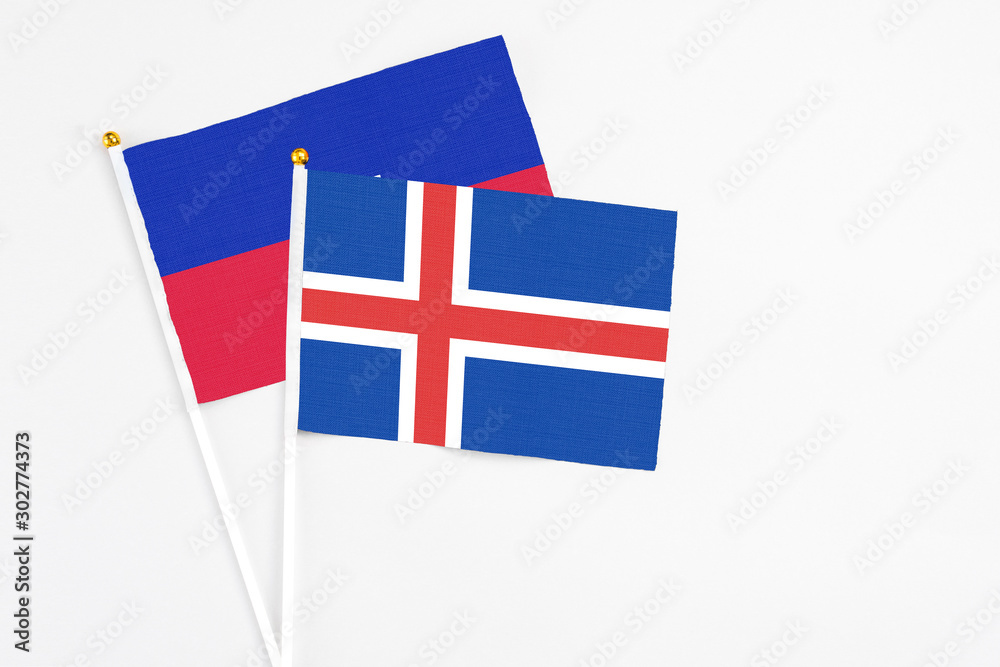 Iceland and Haiti stick flags on white background. High quality fabric, miniature national flag. Peaceful global concept.White floor for copy space.