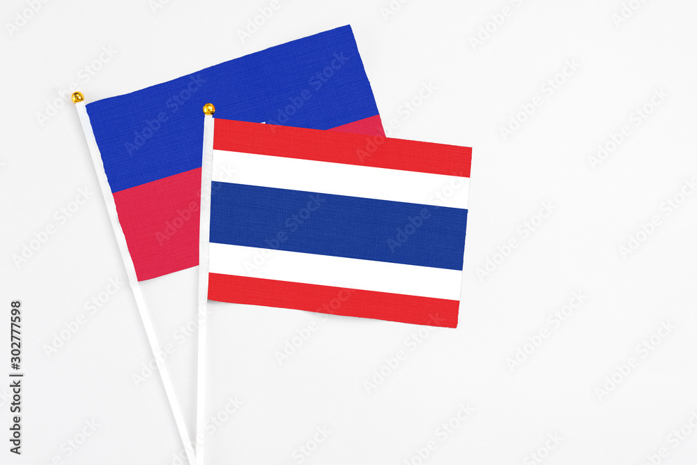 Thailand and Haiti stick flags on white background. High quality fabric, miniature national flag. Peaceful global concept.White floor for copy space.