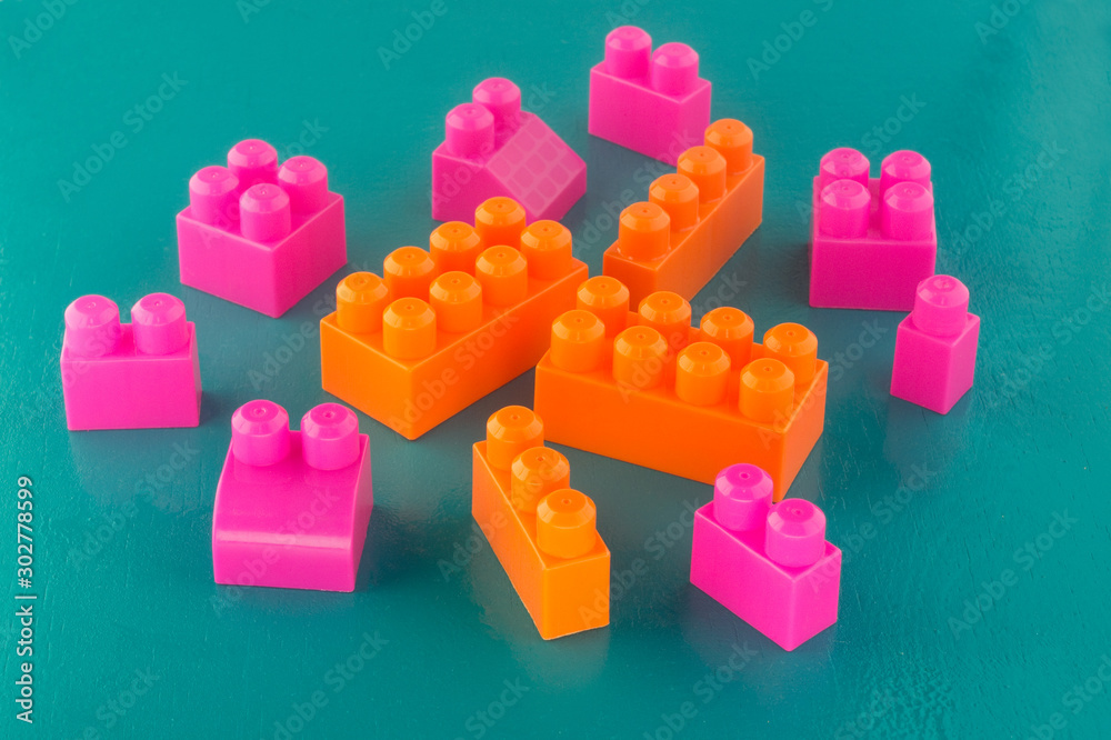 Obraz premium orange and pink bricks of a different size children's designer on a green background