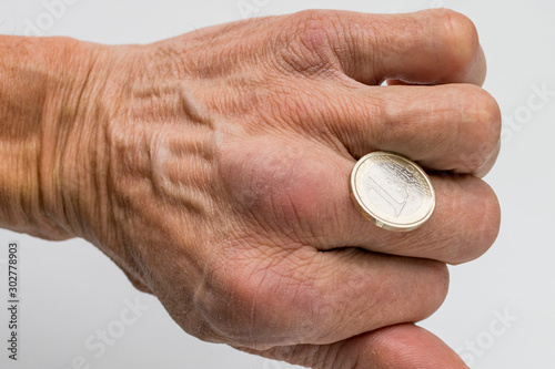 Man's hand holding a Euro coin