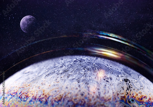Close up surface of soap bubble seems like planet in space night starry sky and moon in a creative collage. Creative background.