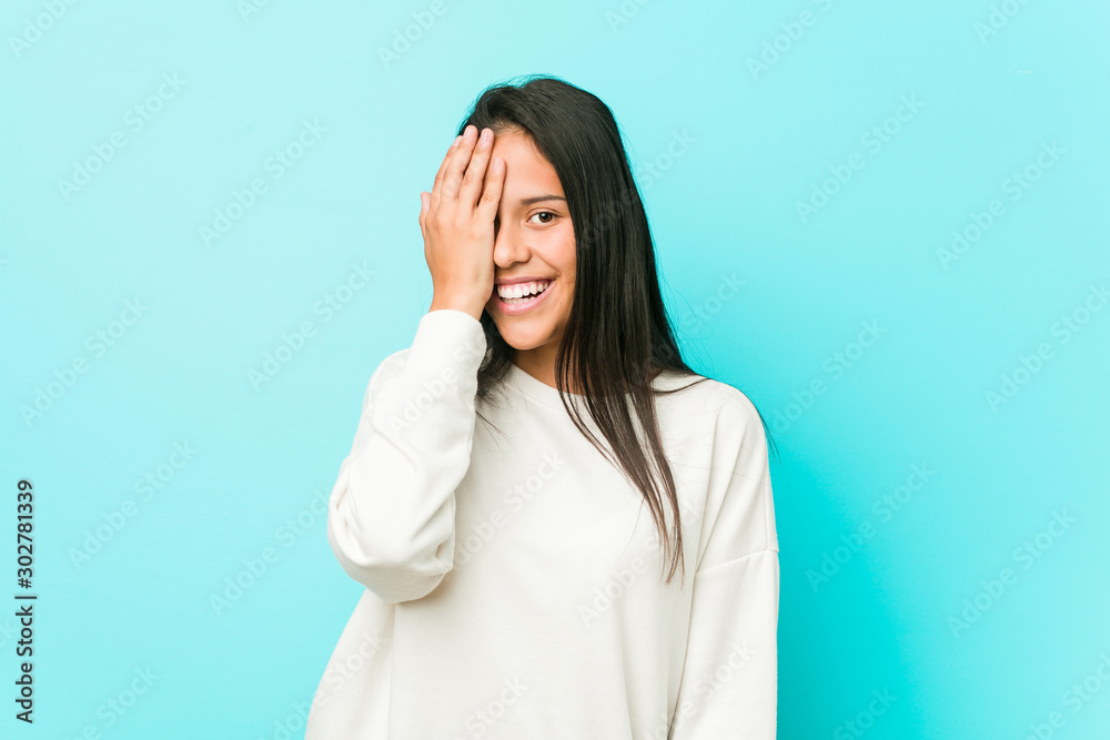 Young pretty hispanic woman having fun covering half of face with palm. Young pretty hispanic woman having fun covering half of face with palm.