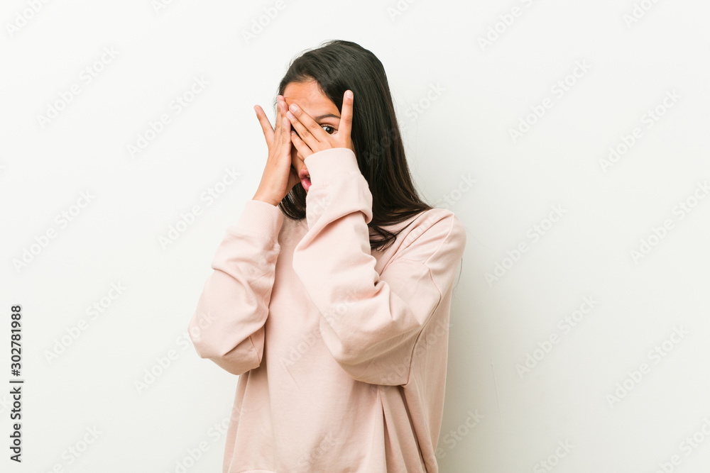 Young cute hispanic teenager woman blink through fingers frightened and nervous. Young cute hispanic teenager woman blink through fingers frightened and nervous.