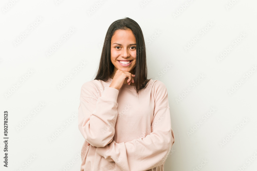 Young cute hispanic teenager woman smiling happy and confident, touching chin with hand. Young cute hispanic teenager woman smiling happy and confident, touching chin with hand.