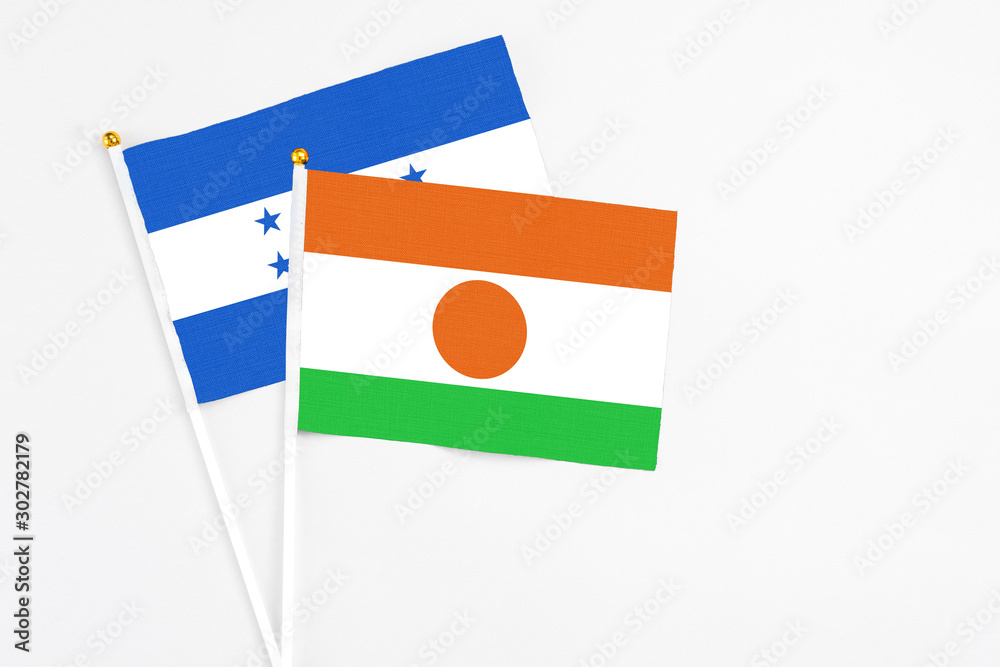 Niger and Honduras stick flags on white background. High quality fabric, miniature national flag. Peaceful global concept.White floor for copy space. Niger and Honduras stick flags on white background. High quality fabric, miniature national flag. Peaceful global concept.White floor for copy space.