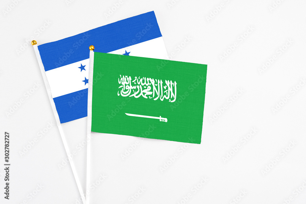 Saudi Arabia and Honduras stick flags on white background. High quality fabric, miniature national flag. Peaceful global concept.White floor for copy space.