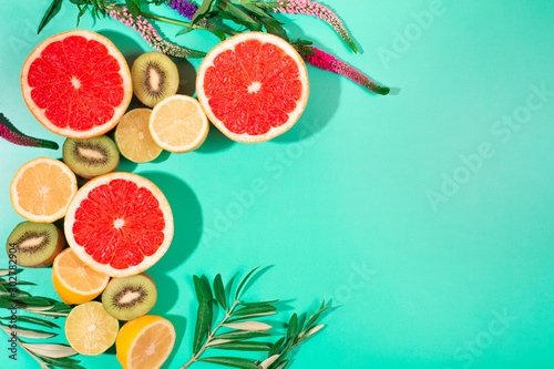 Fruits on trendy green background. Flat lay style.