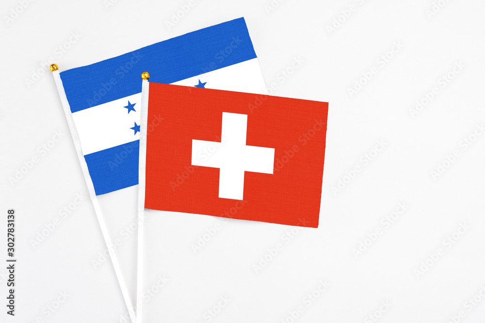 Switzerland and Honduras stick flags on white background. High quality fabric, miniature national flag. Peaceful global concept.White floor for copy space.