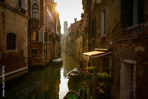 Venice canal at dawn with boats and old architecture