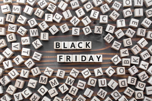 Black Friday - phrase from wooden blocks with letters, Big Deals and Sales concept, banner Black Friday poster, random letters around, wooden background