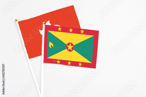 Grenada and Hong Kong stick flags on white background. High quality fabric, miniature national flag. Peaceful global concept.White floor for copy space.