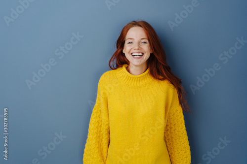Joyful young redhead woman laughing at camera