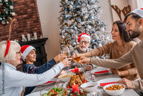 Three generation family enjoying and toasting wine at christmas dinner