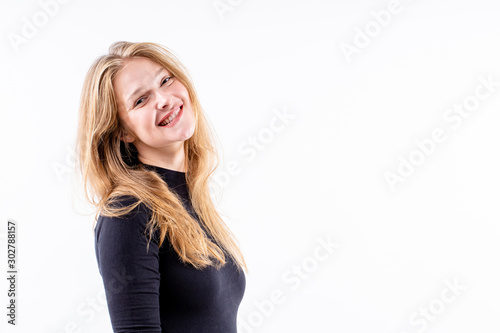 young beautiful blonde girl with a slight smile and a bitten lip on a white background, copy space
