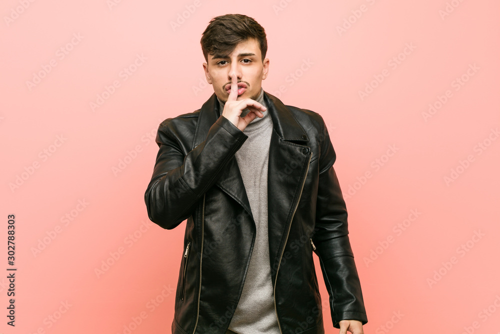 Young hispanic man wearing a leather jacket keeping a secret or asking for silence. Young hispanic man wearing a leather jacket keeping a secret or asking for silence.