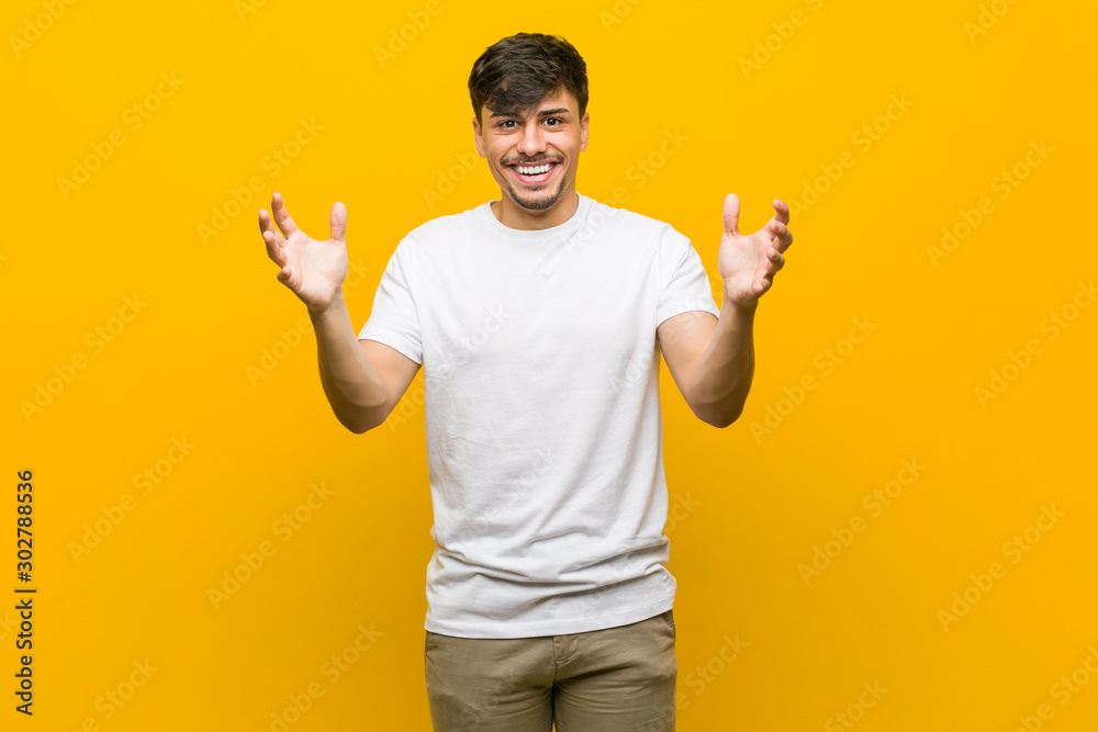 Young hispanic casual man receiving a pleasant surprise, excited and raising hands. Young hispanic casual man receiving a pleasant surprise, excited and raising hands.