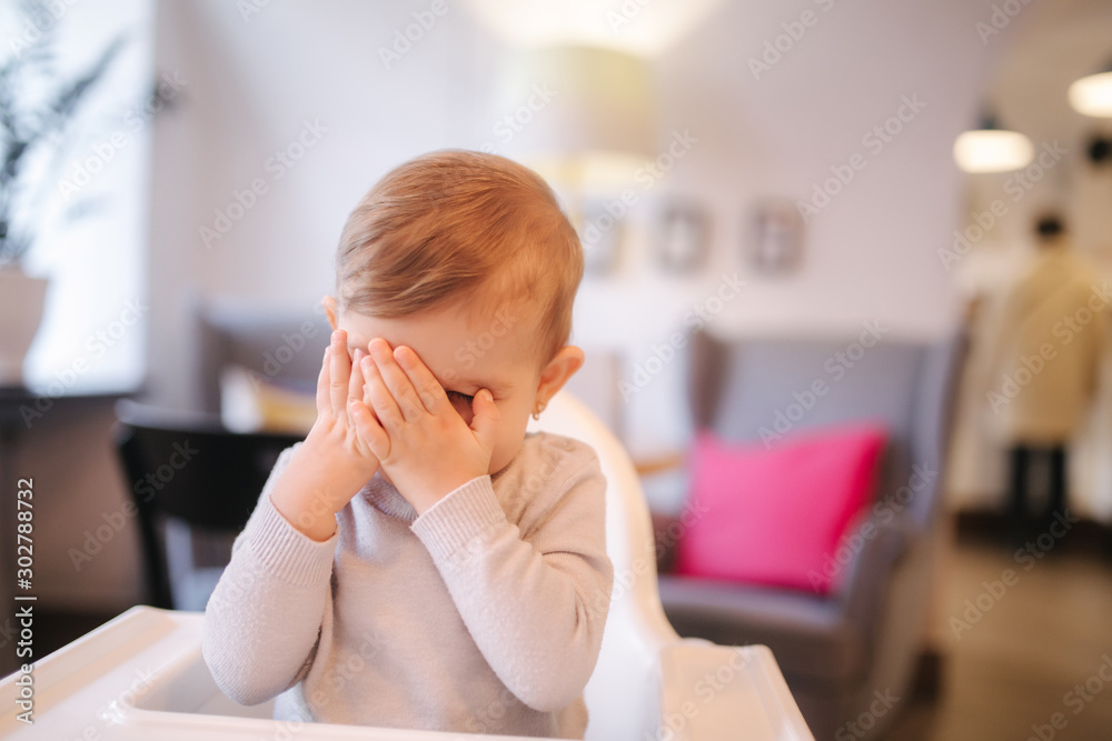 Portrait of adorable little girl on highchair. Baby laughing and play. Happy girl smile Portrait of adorable little girl on highchair. Baby laughing and play. Happy girl smile
