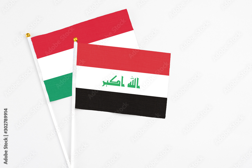 Iraq and Hungary stick flags on white background. High quality fabric, miniature national flag. Peaceful global concept.White floor for copy space. Iraq and Hungary stick flags on white background. High quality fabric, miniature national flag. Peaceful global concept.White floor for copy space.