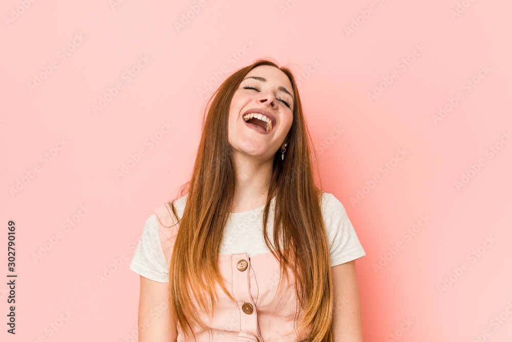 Young ginger woman with freckles relaxed and happy laughing, neck stretched showing teeth. Young ginger woman with freckles relaxed and happy laughing, neck stretched showing teeth.