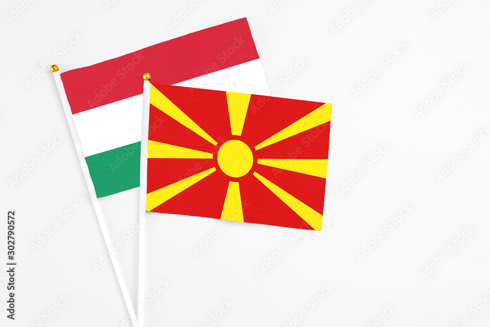 Macedonia and Hungary stick flags on white background. High quality fabric, miniature national flag. Peaceful global concept.White floor for copy space.