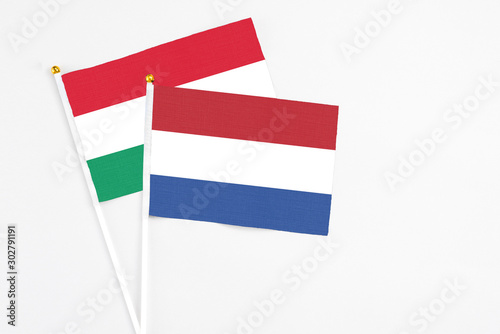 Free Download Netherlands and Hungary stick flags on white background. High quality fabric, miniature national flag. Peaceful global concept.White floor for copy space. - GFXLoad