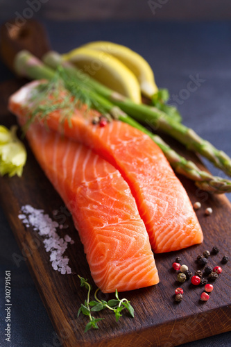 Fresh raw salmon fish fillet, asparagus, lemon, herbs and spices