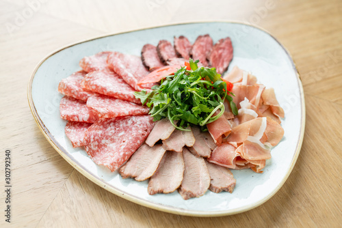 Meat plate, delicacy and Anantipasto. Salami, roast beef, Parma ham, smoked duck breast. Restaurant menu.