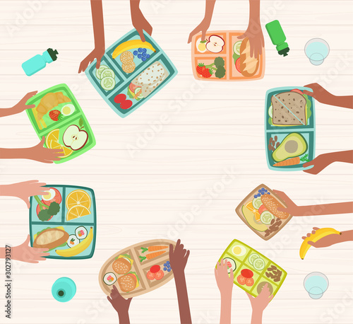 Children hands holding lunch boxes with healthy lunches food on table