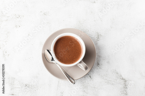 Cup of hot cocoa or hot chocolate or americano in white cup isolated on bright marble background. Horizontal photo. traditional drinks for winter time