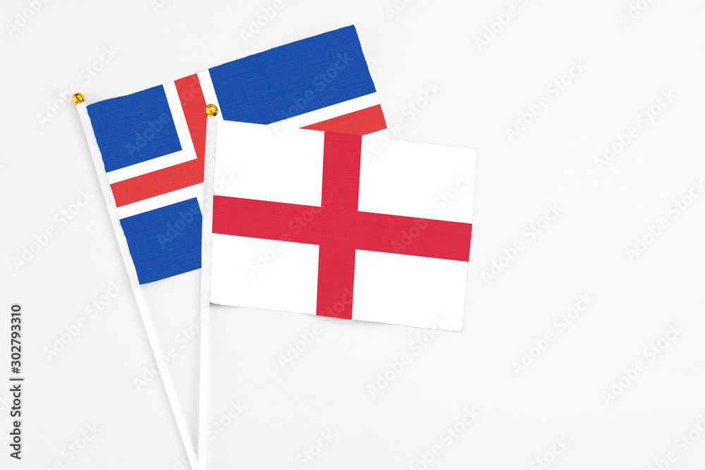 England and Iceland stick flags on white background. High quality fabric, miniature national flag. Peaceful global concept.White floor for copy space.