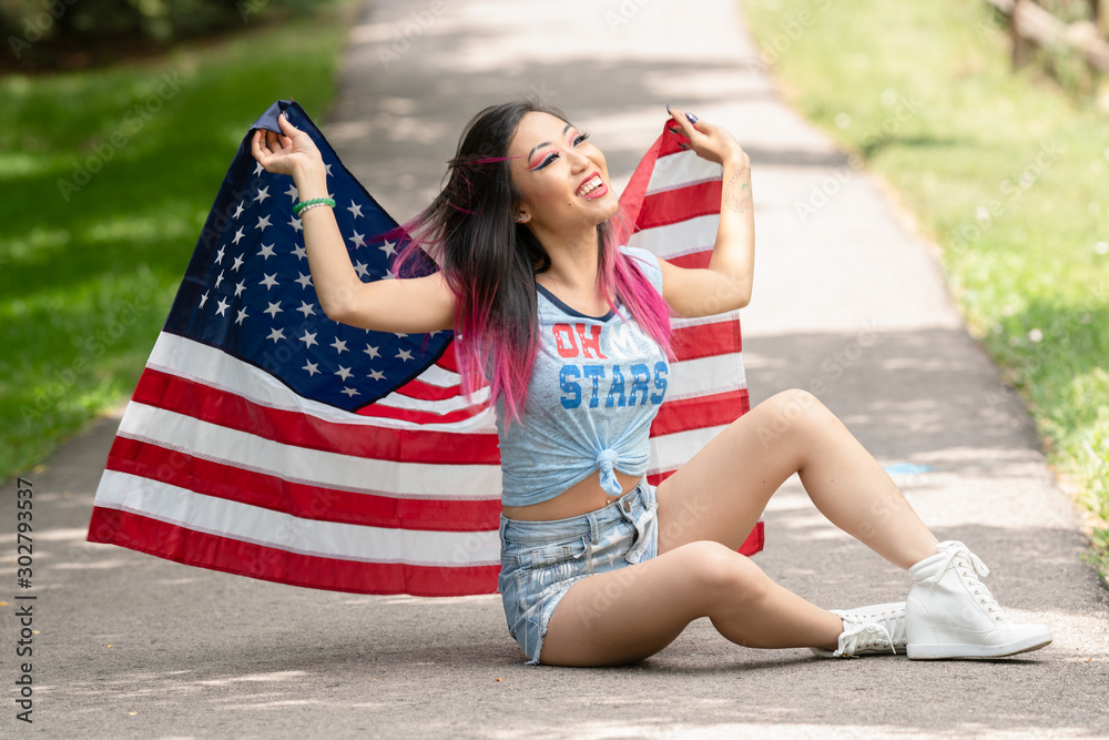 Naklejka premium Beautiful asian girl posing with American Flag