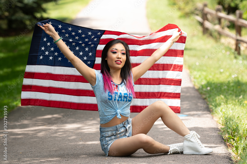 Naklejka premium Beautiful asian girl posing with American Flag