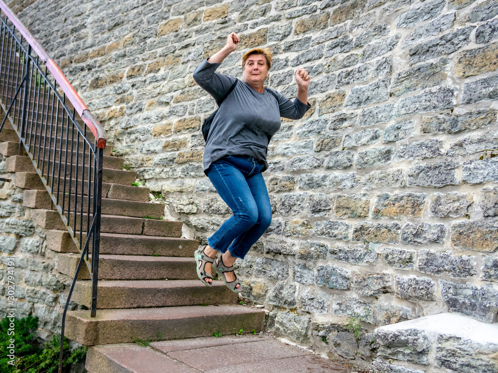 A thoughtful Mature plump woman walks the streets of the old city. She jumps down the steps. Tallinn A thoughtful Mature plump woman walks the streets of the old city. She jumps down the steps. Tallinn