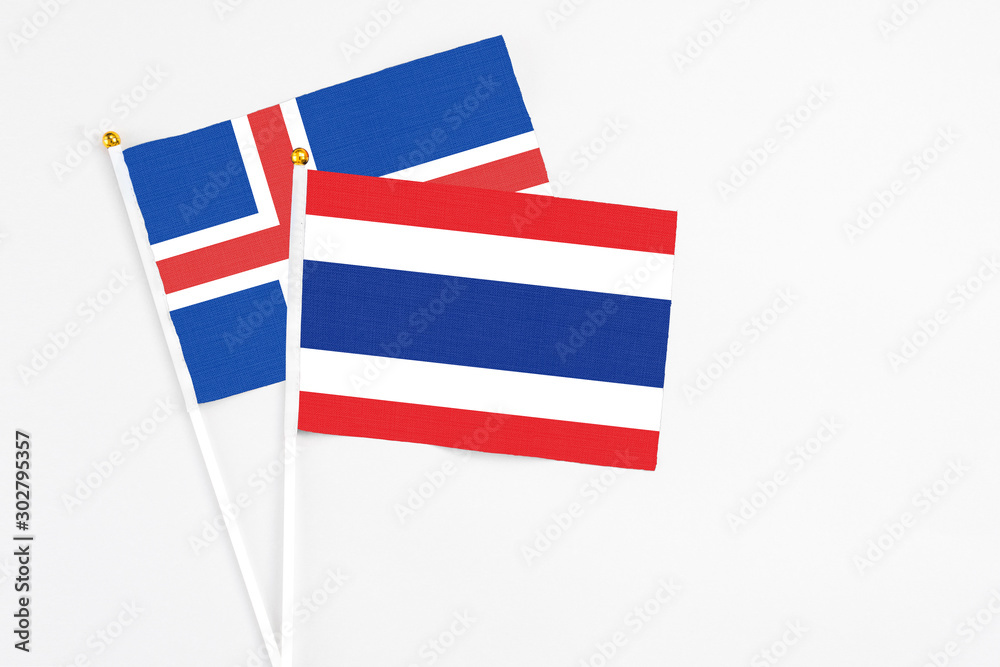 Thailand and Iceland stick flags on white background. High quality fabric, miniature national flag. Peaceful global concept.White floor for copy space.