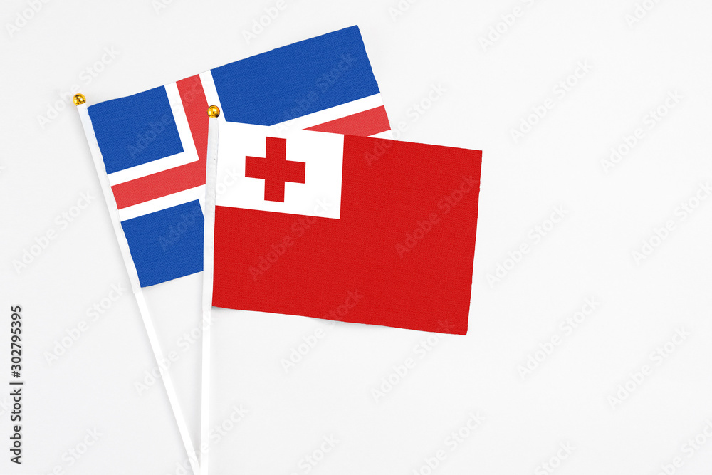 Tonga and Iceland stick flags on white background. High quality fabric, miniature national flag. Peaceful global concept.White floor for copy space.
