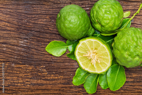 Fresh bergamot fruit with bergamot leaves on old wooden background.