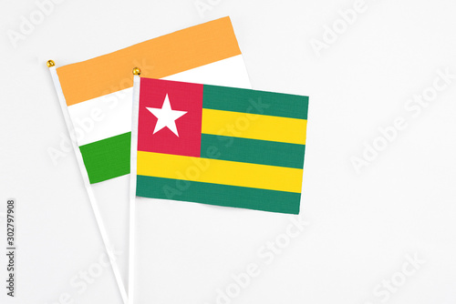 Togo and India stick flags on white background. High quality fabric  miniature national flag. Peaceful global concept.White floor for copy space.