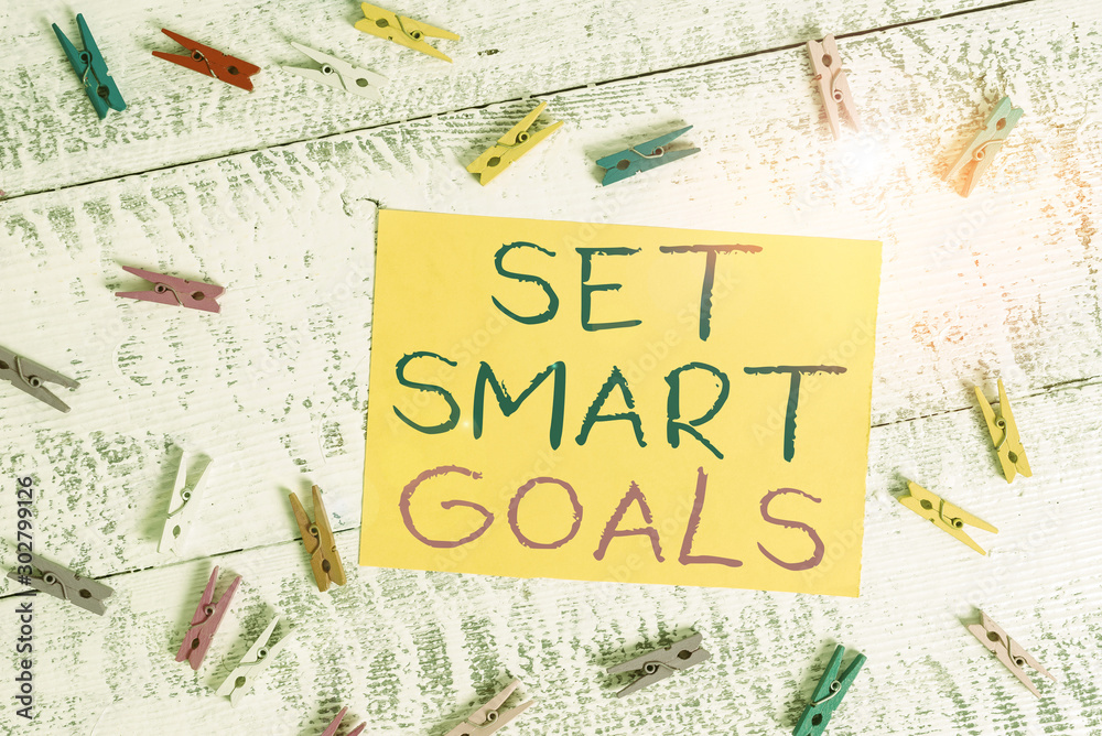 Conceptual hand writing showing Set Smart Goals. Concept meaning Establish achievable objectives Make good business plans Colored clothespin rectangle shaped paper blue background