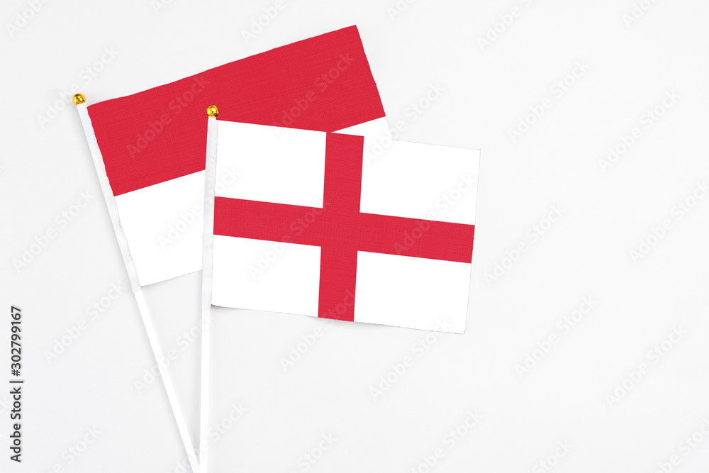 England and Indonesia stick flags on white background. High quality fabric, miniature national flag. Peaceful global concept.White floor for copy space.