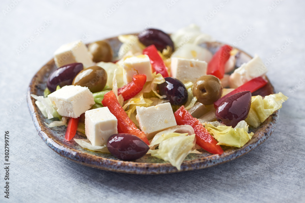Salad with Green and Kalamata Olives, Red Pepper and Feta Cheese on Bright Stone Background. Healthy Snack Idea. Close up. Salad with Green and Kalamata Olives, Red Pepper and Feta Cheese on Bright Stone Background. Healthy Snack Idea. Close up.