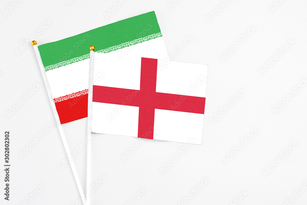 England and Iran stick flags on white background. High quality fabric, miniature national flag. Peaceful global concept.White floor for copy space.