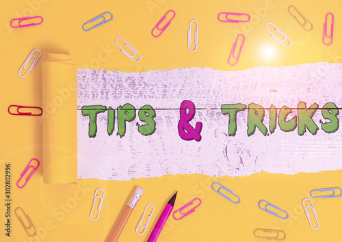 Word writing text Tips And Tricks. Business photo showcasing Steps Lifehacks Handy advice Recommendations Skills Stationary and torn cardboard placed above a wooden classic table backdrop photo