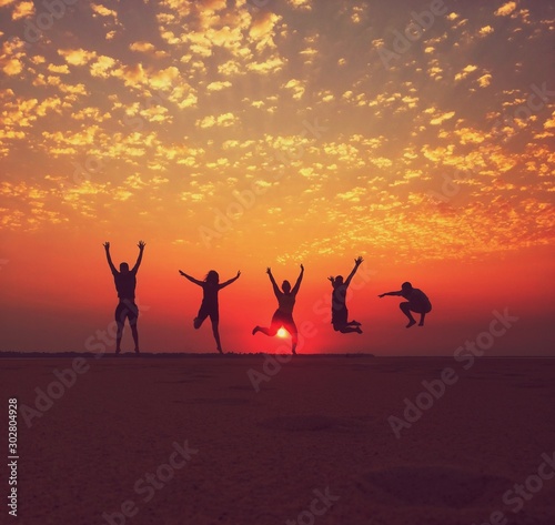 group of people dancing at sunset