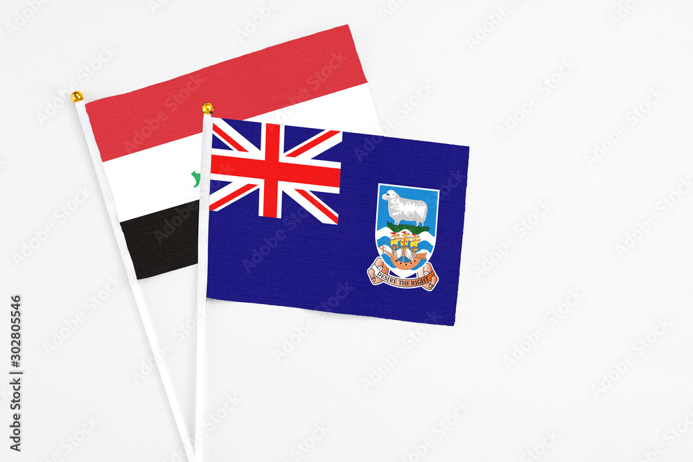 Fototapeta premium Falkland Islands and Iraq stick flags on white background. High quality fabric, miniature national flag. Peaceful global concept.White floor for copy space.