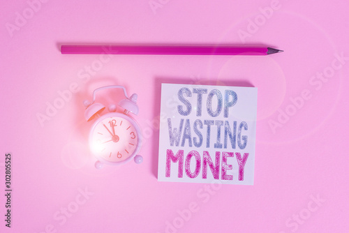 Word writing text Stop Wasting Money. Business photo showcasing Organizing Management Schedule lets do it Start Now Metal vintage alarm clock wakeup blank notepad marker colored background